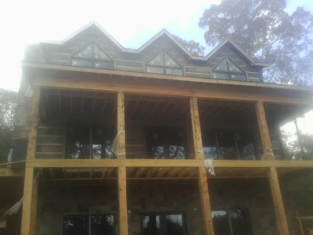 Dormers and porch framing on a large log home under construction — Roof Coating work by our crew in Salisbury